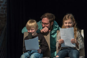 Leseförderung: Kinder lesen auf der Bühne einen Text vor.